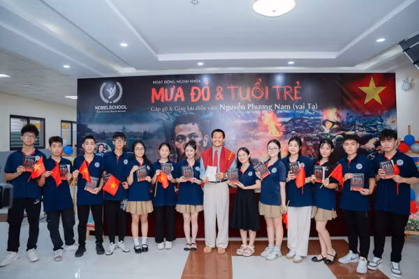 Diễn viên Phương Nam trao tặng sách "Mưa đỏ" cho học sinh.