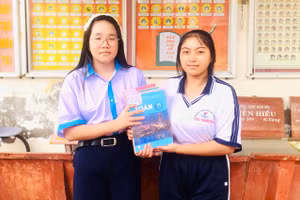 Học sinh lớp trên tặng sách giáo khoa cho học sinh lớp dưới. 
