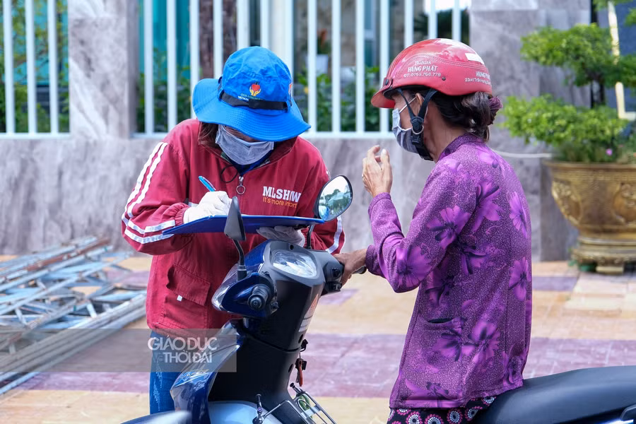 Tình nguyện viên đội nắng lấy thông tin dịch tễ người dân vào thành phố.