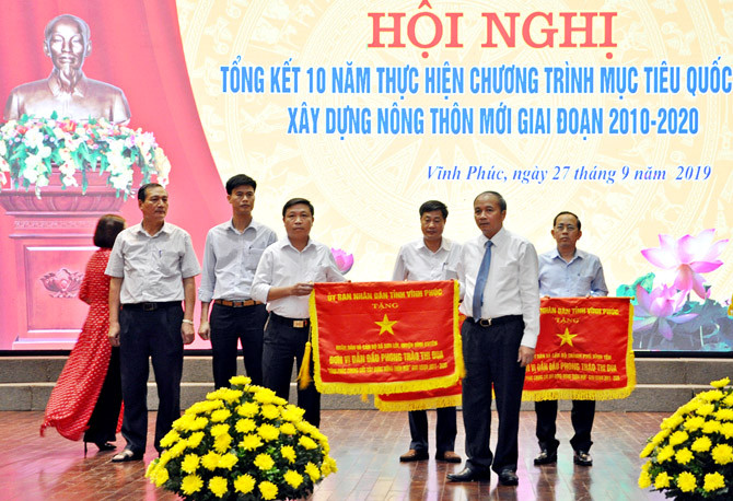 Ông Nguyễn Văn Trì- Chủ tịch UBND tỉnh Vĩnh Phúc trao cờ thi đua xuất sắc cho các tập thể có thành tích xuất sắc trong phong trào thi đua: Vĩnh Phúc chung sức xây dựng nông thôn mới.