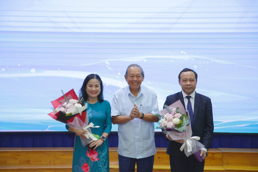 Nguyên Phó Thủ tướng Trương Hòa Bình trao tặng lẵng hoa cho PGS.TS Vũ Hải Quân và PGS.TS Ngô Thị Phương Lan.