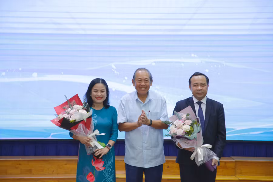 Nguyên Phó Thủ tướng Trương Hòa Bình trao tặng lẵng hoa cho PGS.TS Vũ Hải Quân và PGS.TS Ngô Thị Phương Lan.