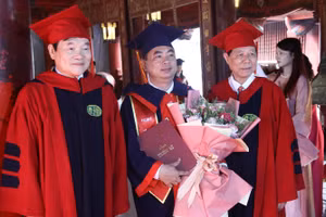 PGS.TS Phạm Dương Châu và PGS, TS Phạm Văn Đăng - Phó Viện trưởng thường trực Viện đào tạo Sau đại học trao bằng và tặng hoa cho tân tiến sĩ.