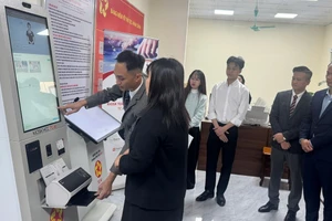 Đại diện đơn vị tài trợ và lãnh đạo UBND xã Nghĩa Trụ quan sát và hỗ trợ người dân đến trải nghiệm robot trong ngày 30/12. Ảnh: T.Đảng