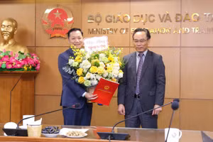 Thứ trưởng Bộ GD&ĐT Hoàng Minh Sơn (bên phải) trao Quyết định và tặng hoa chúc mừng tân Vụ trưởng Vụ Giáo dục đại học Nguyễn Tiến Thảo.