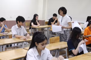 Giám thị phát giấy thi cho thí sinh.