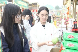 Sinh viên Trần Thu Trang (áo trắng) giới thiệu sản phẩm khi tham gia Hội chợ xuân Bính Ngọ 2026.