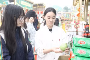 Sinh viên Trần Thu Trang (áo trắng) giới thiệu sản phẩm khi tham gia Hội chợ xuân Bính Ngọ 2026.