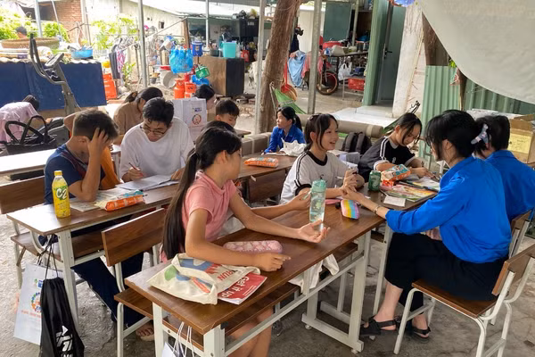 Những bạn trẻ mang áo xanh tình nguyện dạy học cho em nhỏ ở xóm trọ phường Thảo Điền, TPHCM. Ảnh: Phúc Uyên.