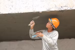 Người thợ tỉ mỉ hoàn thiện trần lớp học trước ngày công trình về đích. (Ảnh: Thế Hùng)