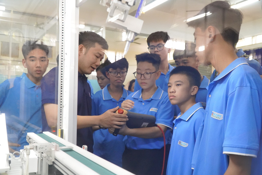 Les élèves du pensionnat Hope utilisent un bras robotisé au Centre d'expérimentation des moteurs et de l'automobile de l'Université des sciences et technologies de Da Nang. Photo : NTCC tang-nguon-tuyen-cho-nganh-stem-1.jpg