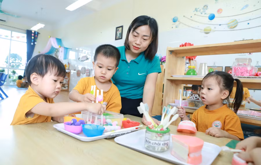 Trẻ tại Trường Mầm non An Khánh B (An Khánh, Hà Nội) trong một hoạt động góc dưới sự hướng dẫn của cô giáo. Ảnh: Đình Tuệ