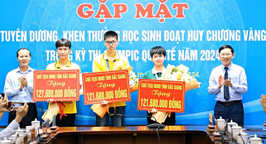 Chủ tịch UBND tỉnh Bắc Giang Lê Ánh Dương (bên phải) tặng hoa chúc mừng 3 học sinh đoạt Huy chương Vàng Olympic quốc tế.