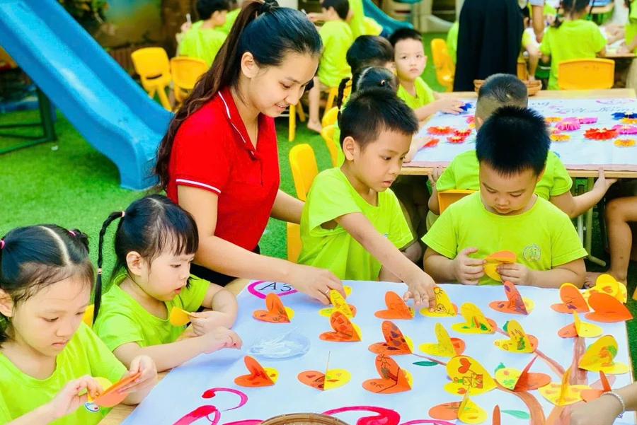 Cô giáo hướng dẫn trẻ làm đồ chơi tại Trường Mầm non Hà Trì (Hà Đông, Hà Nội). Ảnh: Đình Tuệ