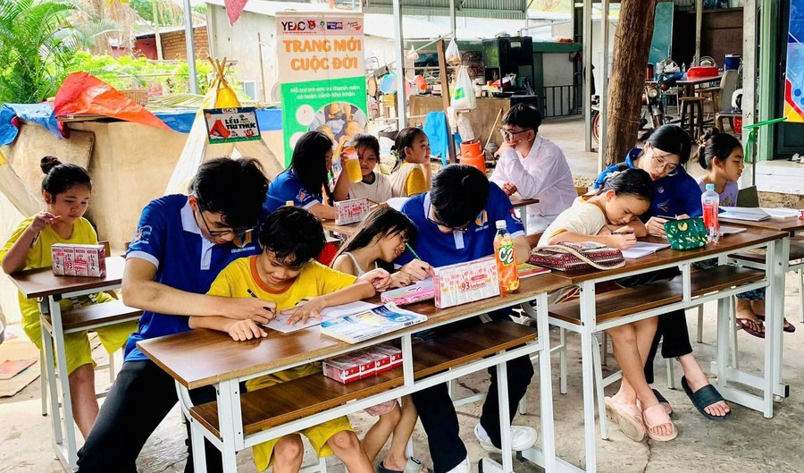 Các gia sư áo xanh dạy học cho trẻ tại “Lớp viết tiếp tương lai”. Ảnh: NVCC