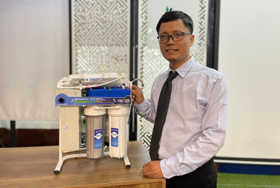 TS Đỗ Hữu Quyết bên hệ thống lọc nước do mình chế tạo. Ảnh: Hà An