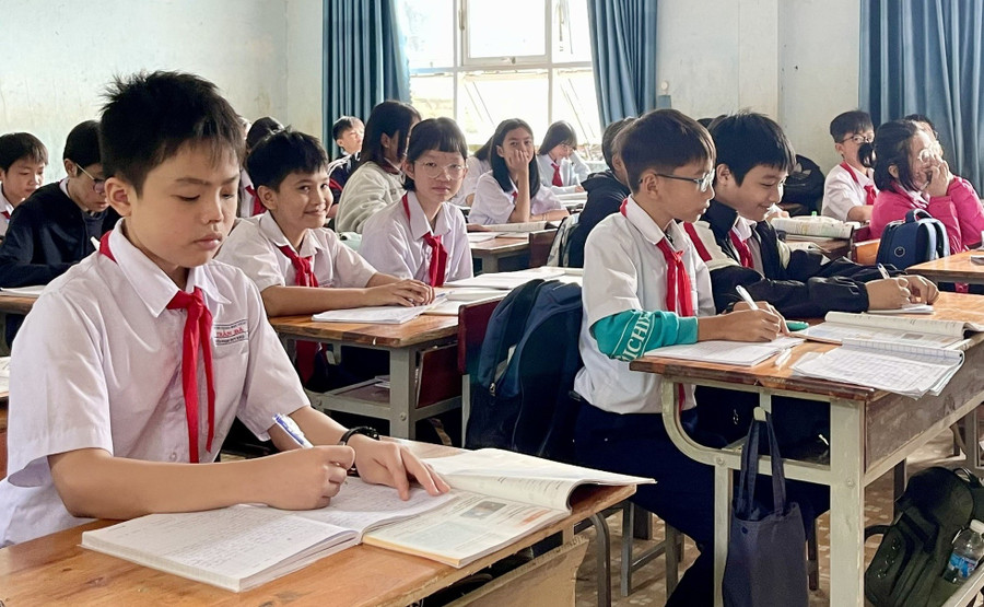 Một số học sinh bị hư hỏng sách giáo khoa trong đợt mưa lũ, phải dùng chung sách với bạn để chờ được hỗ trợ. Ảnh: Dung Nguyễn