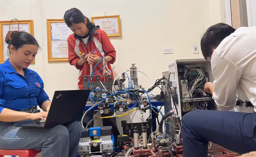 Cô Nguyễn Thùy Dương (ngoài cùng bên trái) hướng dẫn hai học sinh Nguyễn Tiến Mạnh và Dương Thị Duyên thực hiện đề tài “Máy tách, tuốt vỏ cây tế - nguyên liệu sản xuất sản phẩm tiêu dùng xanh”. Ảnh: NVCC