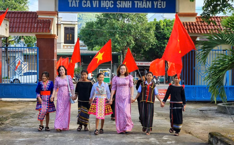 Học sinh miền núi Đắk Lắk đến trường trong vòng tay thầy cô. Ảnh tư liệu