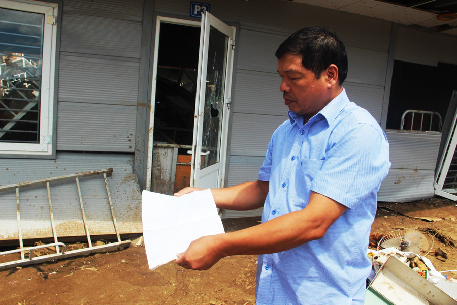 Ông Phạm Văn Kiên - Hiệu trưởng Trường PTDTBT-THCS Tam Chung nhặt nhạnh từng cuốn vở của học trò sau cơn lũ dữ. hai-trai-tim-mot-nhip-dap-gieo-chu-3.jpg