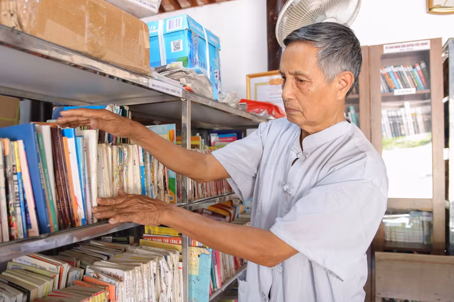 Cựu chiến binh Nguyễn Văn Lạc sửa soạn sách trong thư viện.
