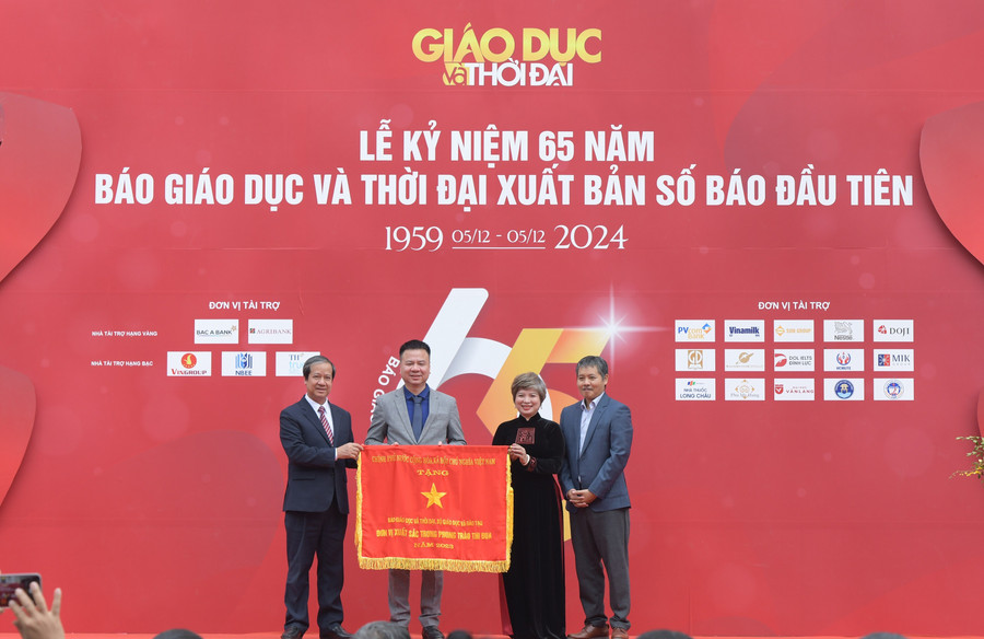Bộ trưởng Nguyễn Kim Sơn trao Cờ thi đua của Chính phủ cho Báo Giáo dục và Thời đại dịp kỷ niệm 65 năm ngày Báo Giáo dục và Thời đại xuất bản số báo đầu tiên. Ảnh: Trần Hiệp