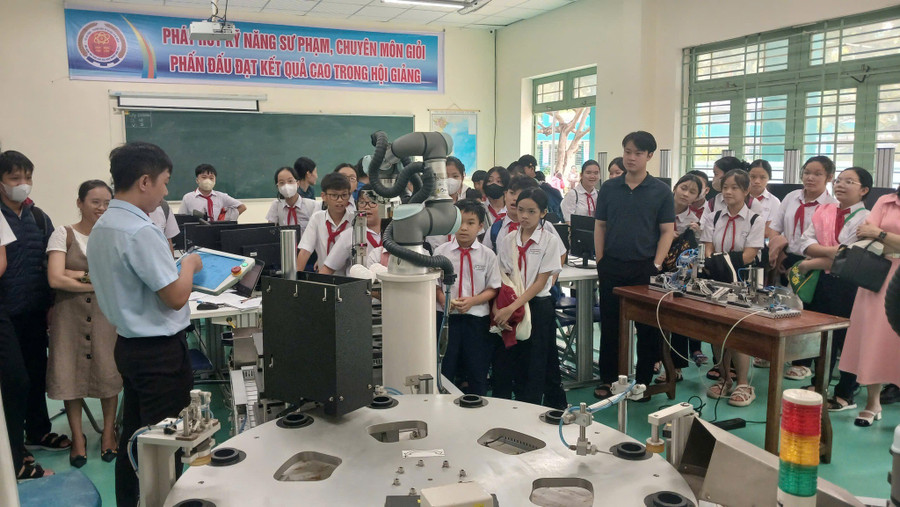 Học sinh Trường THCS Hồ Nghinh (Hải Châu, Đà Nẵng) tìm hiểu mô hình robot và hệ thống điện tái tạo tại phòng thực hành, Trường Cao đẳng Lương thực - Thực phẩm Đà Nẵng. Ảnh: NTCC