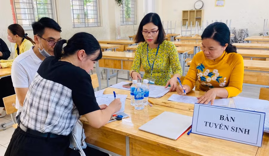 Giáo viên Trường THCS Lĩnh Nam (Hoàng Mai, Hà Nội) hỗ trợ cha mẹ học sinh đăng ký tuyển sinh đầu cấp năm học 2024 - 2025. 