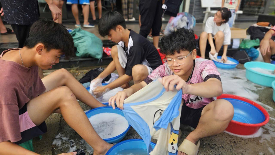 Học sinh Trường nội trú Hy vọng giặt sạch áo quần để phân loại trước khi gửi tặng các bạn vùng lũ. Ảnh: NTCC 
