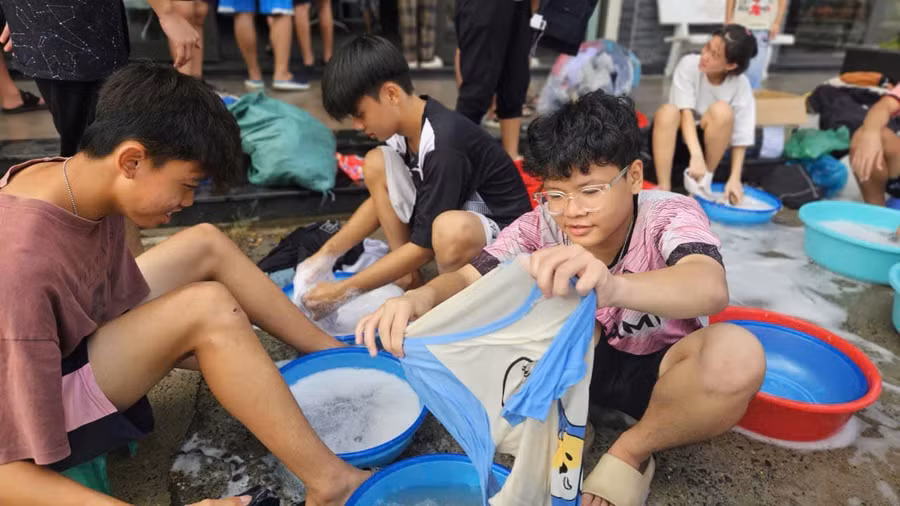 Học sinh Trường nội trú Hy vọng giặt sạch áo quần để phân loại trước khi gửi tặng các bạn vùng lũ. Ảnh: NTCC 