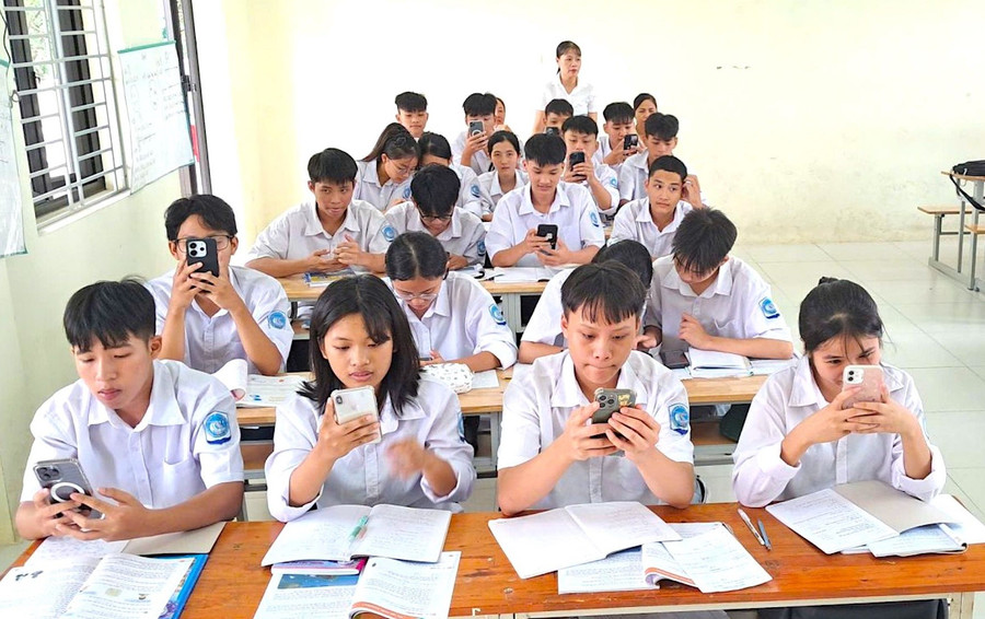 Học sinh Trường THPT Đức Hợp sử dụng điện thoại có kết nối Internet tham gia hoạt động luyện tập trên Quizizz. Ảnh: NNTC luc-luong-tien-phong-3.jpg