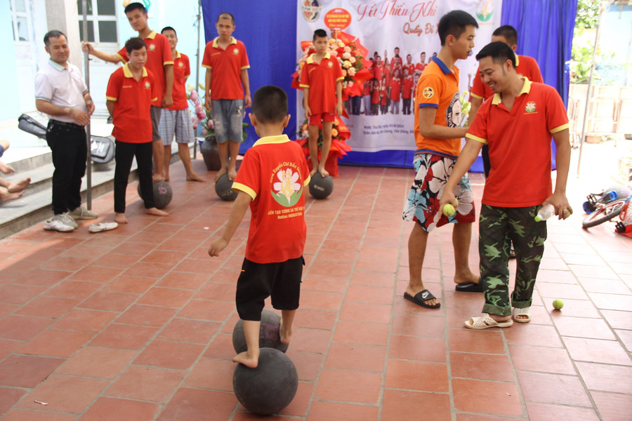 Thầy Vũ Văn Chức hướng dẫn trẻ tự kỷ di chuyển bằng bóng. Ảnh: TG