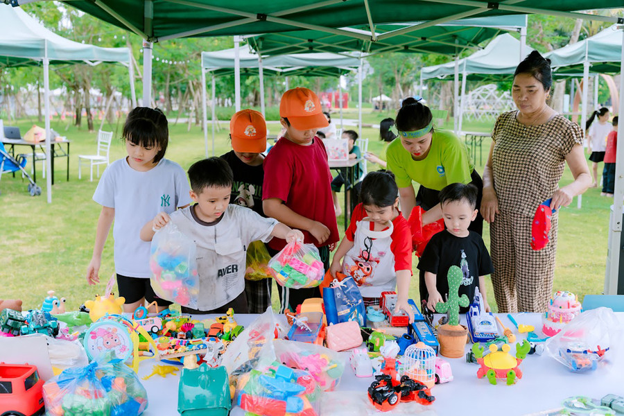 Các em nhỏ hào hứng lựa chọn đồ chơi tại gian hàng đổi đồ cũ.