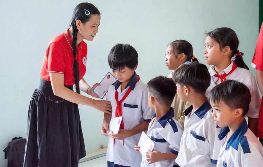 Cô Nguyễn Thị Minh Tâm trao học bổng Nhất Tâm cho học sinh có hoàn cảnh khó khăn. Ảnh: M.H