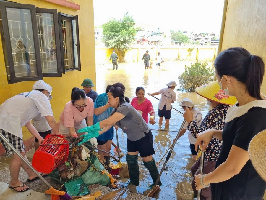 Các cô giáo, cán bộ, nhân viên Trường Tiểu học Nguyễn Thái Học khẩn trương khắc phục thiệt hại sau mưa lũ.