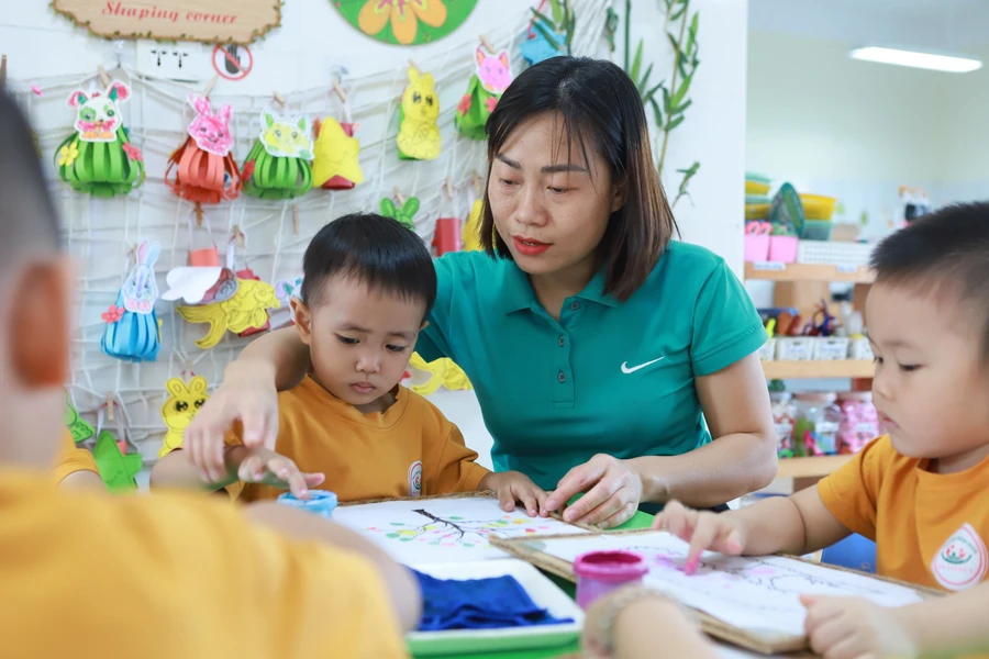 Cô Bùi Thị Thu Hà - giáo viên Trường Mầm non An Khánh B (Hoài Đức, Hà Nội) hướng dẫn trẻ sử dụng màu vẽ tranh. Ảnh: TG