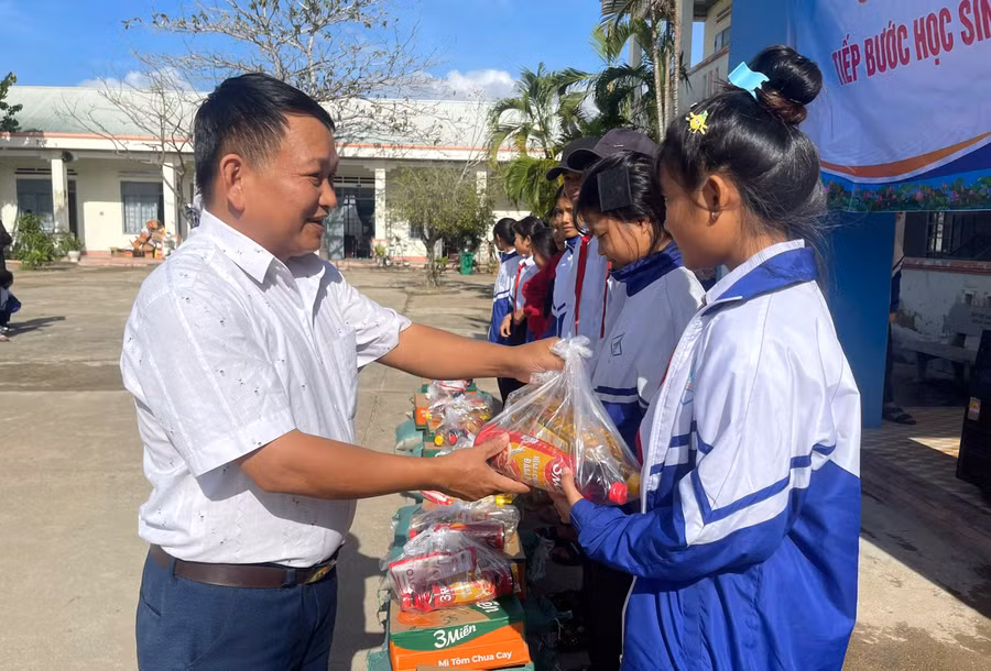 Thầy Vũ Văn Tùng - Trường Tiểu học và THCS Đinh Núp (Gia Lai) mang những phần quà đến học sinh vùng khó.