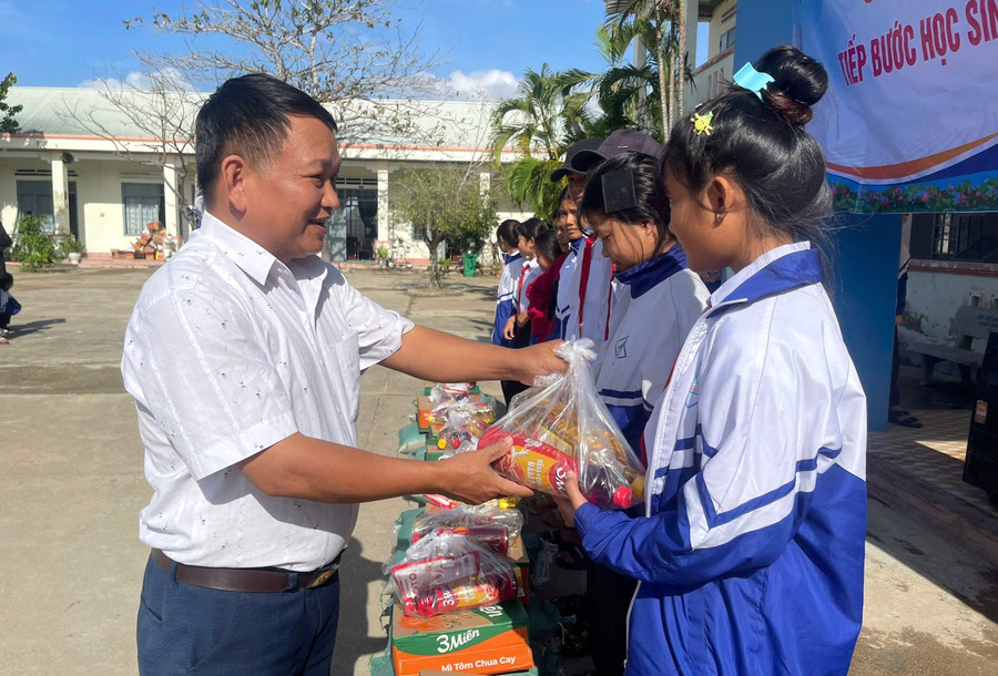 Thầy Vũ Văn Tùng - Trường Tiểu học và THCS Đinh Núp (Gia Lai) mang những phần quà đến học sinh vùng khó.