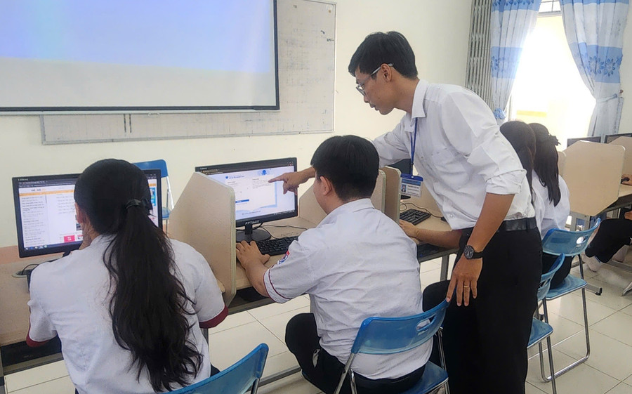 Giáo viên Trường THPT Trần Đại Nghĩa (Cần Thơ) hướng dẫn học sinh đăng ký dự thi trực tuyến. Ảnh: NTCC