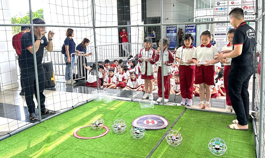Học sinh thích thú khi trải nghiệm trò chơi đá bóng trên không (drone soccer). Ảnh: SHTP-IC