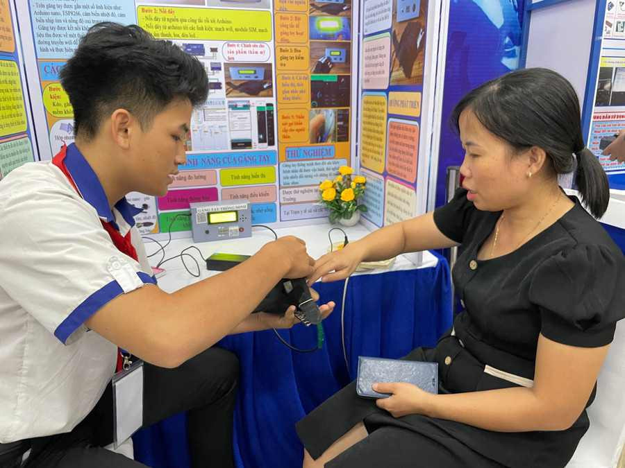 Thử nghiệm sản phẩm găng tay thông minh của nhóm học sinh Trường THCS Lưu Văn Mót. Ảnh: Hà An