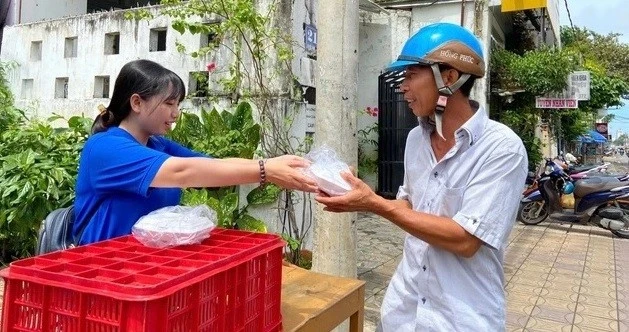 Nguyễn Lê Thảo Vy cùng một người bạn nấu cơm chay tặng bà con khó khăn. Ảnh: NVCC