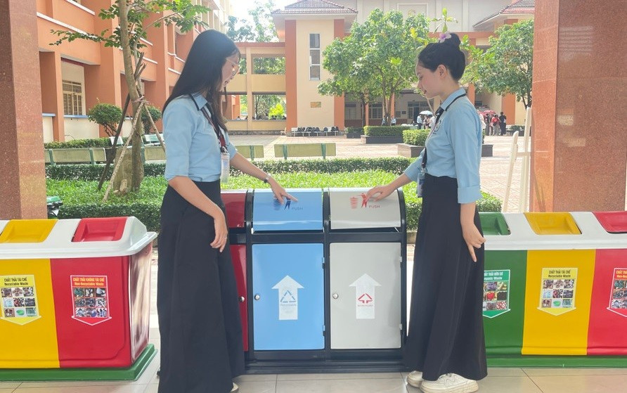 Sinh viên tìm hiểu về thùng phân loại rác tại sự kiện “Dệt xanh” năm 2025. Ảnh: Thùy Linh