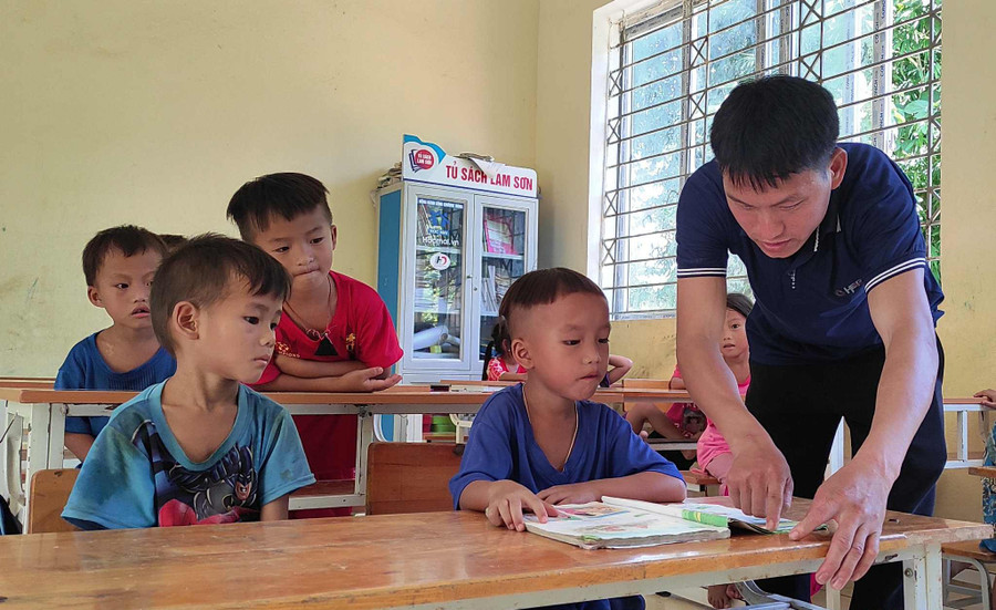 Giáo viên tại điểm lẻ Tà Cóm - Trường Tiểu học Trung Lý 2 (Thanh Hóa) hướng dẫn học sinh lớp 1 tập đọc.