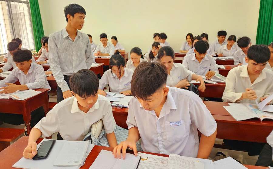 Thầy Phạm Văn Quang cùng học sinh Trung tâm GDTX tỉnh Đắk Lắk ôn tập môn Toán. Ảnh: Thành Tâm