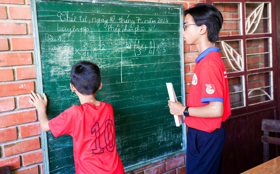 Tình nguyện viên của Đội tình nguyện Hoa phượng đỏ Trường THPT Hoàng Hoa Thám dạy phụ đạo cho học sinh tiểu học Làng trẻ em SOS. Ảnh: NTCC