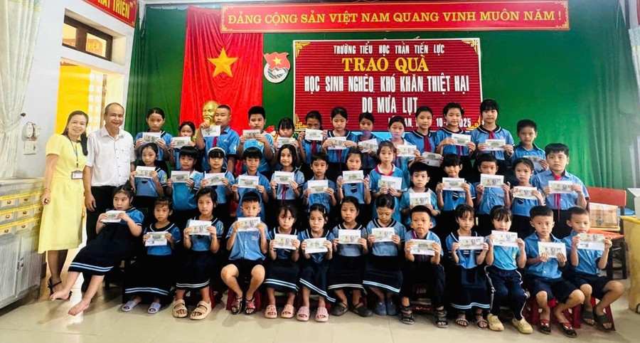 Tác giả thay mặt nhà hảo tâm tặng quà sau lụt cho học sinh bị thiệt hại sau cơn lũ cuối tháng 10 tại Trường Tiểu học Trần Tiến Lực, TP Huế. Ảnh: NVCC