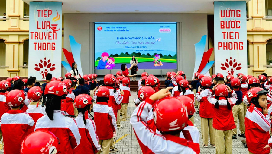 Giáo viên hướng dẫn học sinh cách đội mũ bảo hiểm đúng cách tại Trường Tiểu học Trần Nhân Tông. giao-duc-ky-nang-song-3.jpg