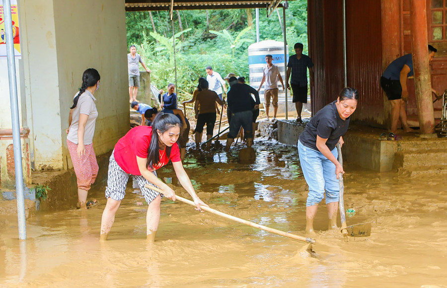 Giáo viên Trường Phổ thông DTBT Tiểu học Lượng Minh dọn dẹp sân trường sau lũ quét vào đêm 30/9. Ảnh: Phạm Tâm