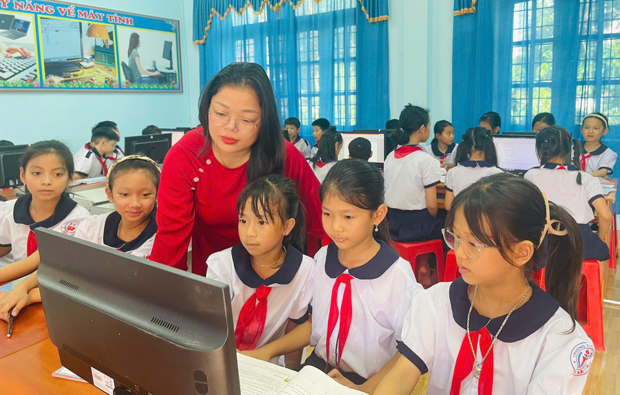 Cô giáo Trần Thị Huệ hướng dẫn học sinh thực hành môn Tin học. Ảnh: Đăng Đức